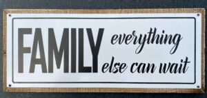 Tekstbord met houten lijst; "family everything else can wait"
